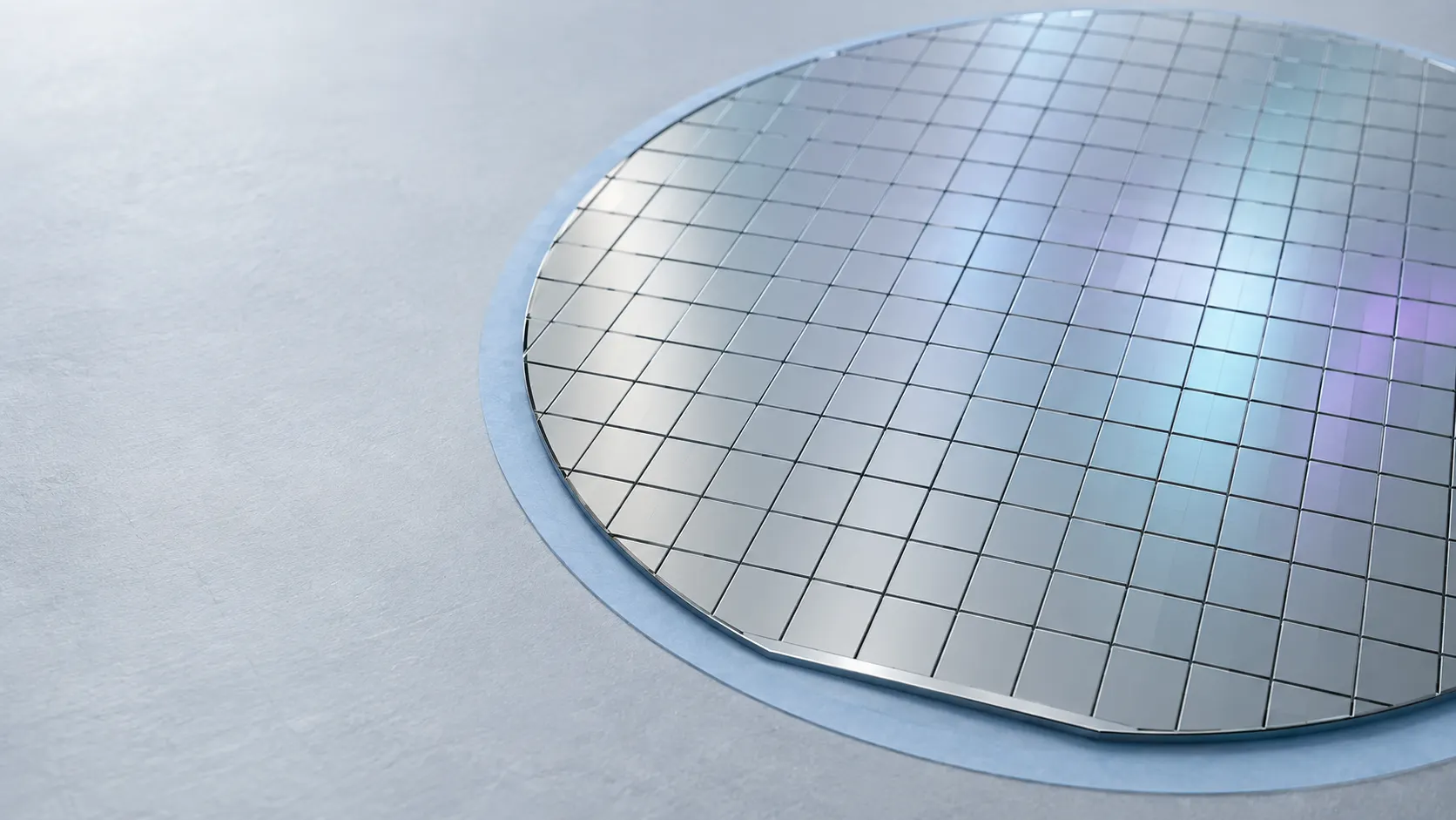 Illustration of a silicon wafer diced into a precise grid, held on dicing tape.